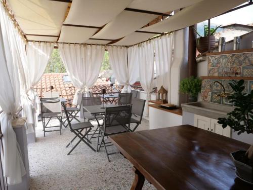 卡馬約雷的住宿－B&B Relais dell'Angelo，一间设有白色窗帘和桌椅的用餐室