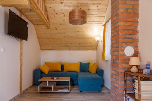 a living room with a blue couch with yellow pillows at Villa M in Vinci