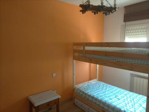 1 dormitorio con 2 literas y mesa en Chalet adosado con jardín, en Cebreros