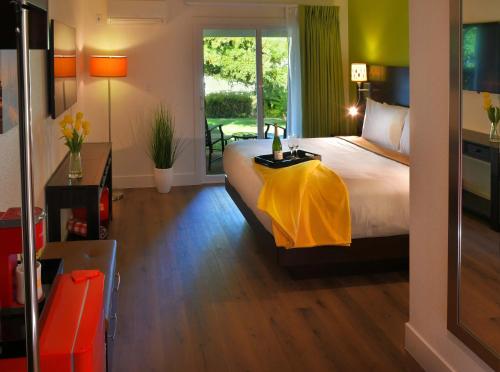 een slaapkamer met een bed met een gele deken erop bij Foothills Motel in Auburn