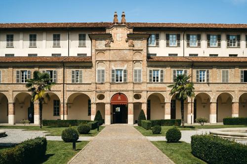 un grand bâtiment avec un chemin menant à celui-ci dans l'établissement Hotel I Somaschi, à Cherasco