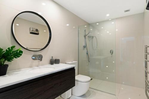 a bathroom with a shower and a sink and a mirror at Lakeview Retreat - Queenstown Holiday Home in Queenstown