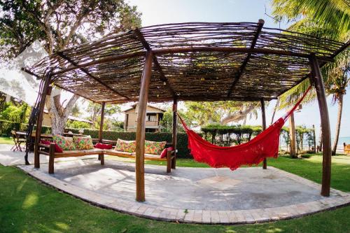 a hammock in a pavilion in a park at Pousada Village Porto Mirim por Carpediem in Jacumã