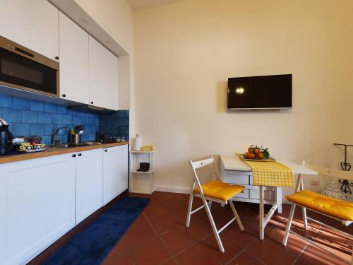 a kitchen with a table and chairs and a tv at Bella Vista House-Sorrento coast - free parking-solarium in Vico Equense