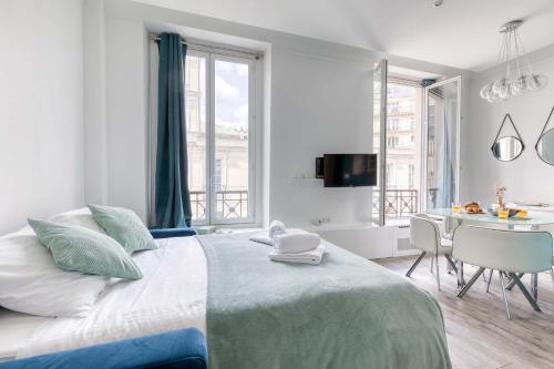 - une chambre avec un grand lit, une table et des chaises dans l'établissement New & Design 1bd Flat in the Heart of le Marais, à Paris