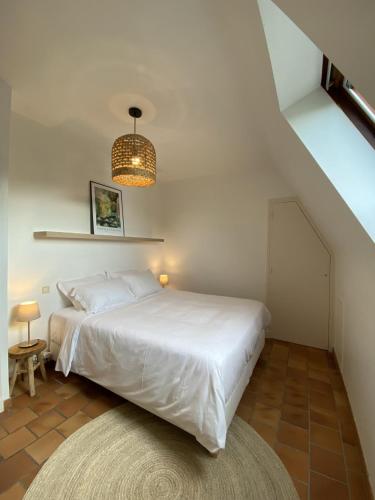 - une chambre avec un lit blanc et un lustre dans l'établissement Les Courtines - Appartement de caractère à la Roque-Gageac - Les Charmilles, à La Roque-Gageac