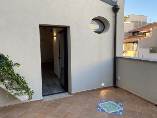 una puerta abierta de una casa con suelo de baldosa en L'Ulivo Comfort Rooms, en Terrasini