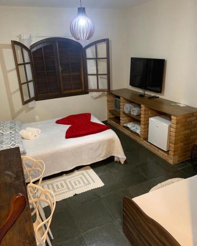 a bedroom with a bed and a flat screen tv at Chales em Salesopolis - Recanto da Barra in Salesópolis