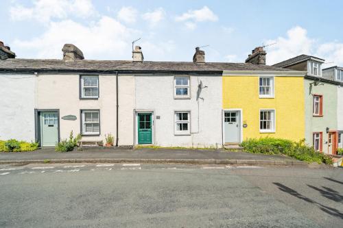 a large white and yellow house with a street at No. 7 in Spark Bridge