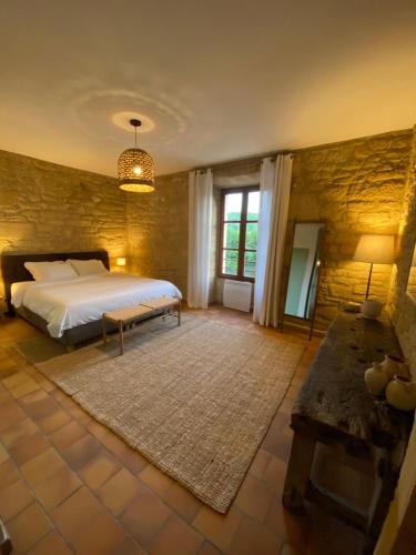 - une grande chambre avec un lit et une table dans l'établissement Les Courtines - Appartement de caractère à la Roque-Gageac - Les Lauriers, à La Roque-Gageac