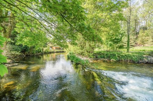 a river with a bridge in the background and trees at No. 7 in Spark Bridge