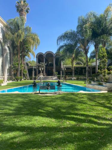 a group of people sitting in chairs by a swimming pool at Gran Hotel Firenze in Tequisquiapan