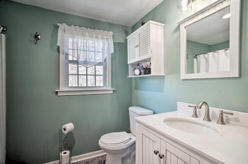 a bathroom with a toilet and a sink and a window at 5 Mi to Beach Cape Cod Getaway with Grill in Sandwich