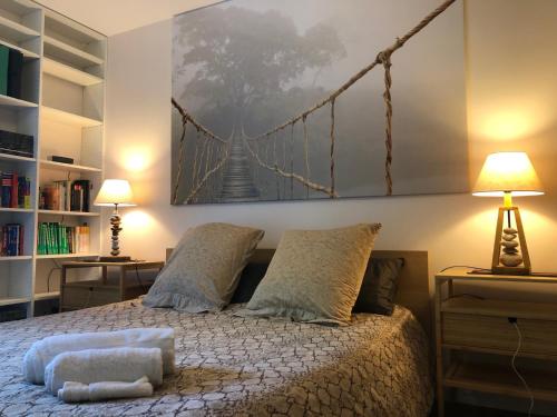 - une chambre dotée d'un lit et d'une peinture de pont sur le mur dans l'établissement Au coeur du bassin...à vélo, au Teich