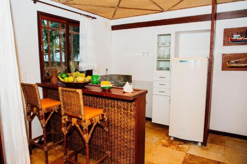 a kitchen with a counter with a bowl of fruit on it at Pousada Village Porto Mirim por Carpediem in Jacumã