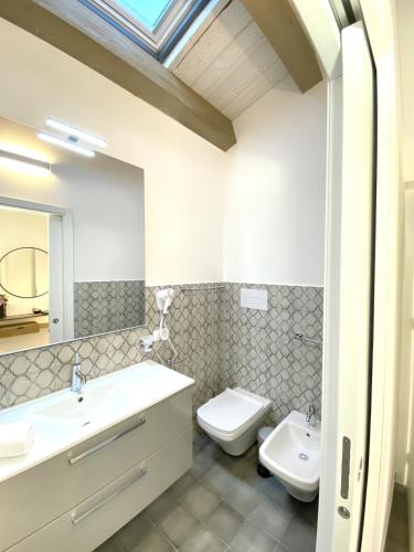 a bathroom with a sink and a toilet and a mirror at L'Ulivo Comfort Rooms in Terrasini