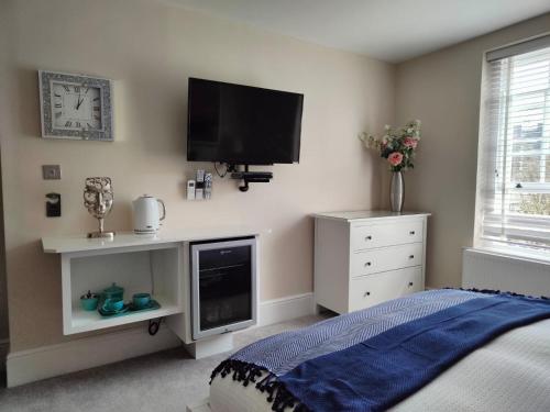 a bedroom with a bed and a tv on the wall at St Johns Boutique Hotel in London
