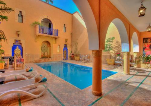 una piscina cubierta en una casa con sillas alrededor en Riad la villa bleue & SPA, en Marrakech