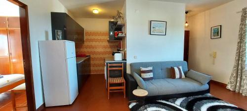 sala de estar con sofá y nevera en Arrifana View Flat - 3 minutos da Praia, en Aljezur