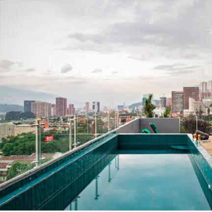 a swimming pool on top of a building with a city at Nido Sky in Medellín