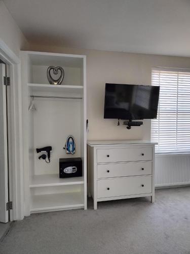 a bedroom with a dresser with a flat screen tv at St Johns Boutique Hotel in London