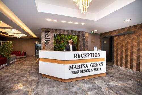 a man standing behind a podium in a lobby at Marina Green Suite & Residence in Trabzon