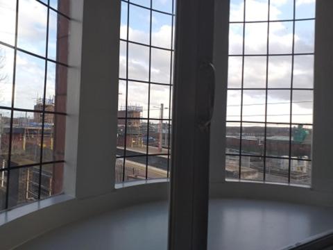 an empty room with two windows looking out at a city at Swan & Railway Hotel Wigan in Wigan