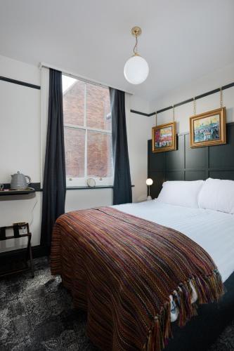 a bedroom with a large bed and a window at Swan & Railway Hotel Wigan in Wigan