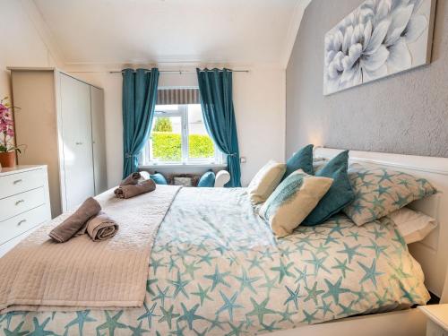 a bedroom with a large bed with blue curtains at Captiva Cottage in Saundersfoot