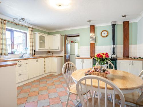 a kitchen with a wooden table and chairs and a table at Highbury in Spittal