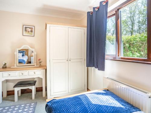 a bedroom with a bed and a desk and a window at Highbury in Spittal