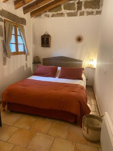 - une chambre avec un lit doté de draps rouges et une fenêtre dans l'établissement BERGERIE Babbu, Domaine de l Ogliastru, à Olmeto