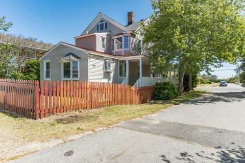 a house with a orange fence in front of it at Captains Quarters by the Bay cottage in Norfolk