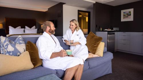 a man and a woman sitting on a couch at Hotel Montreal in Christchurch