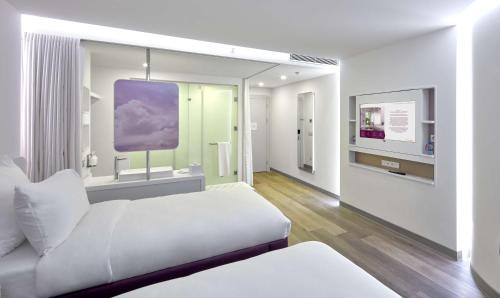 a white room with a bed and a tv at YOTEL Istanbul Airport, City Entrance in Istanbul