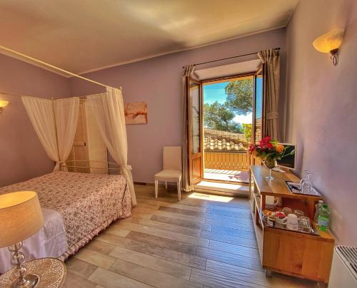 モンテプルチャーノにあるIl Buonumoreのベッドルーム1室(ベッド1台付)、バルコニーへのドアが備わります。
