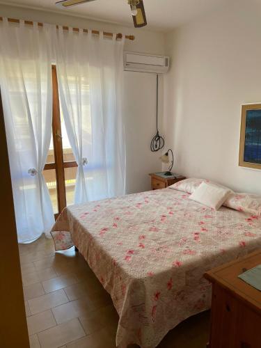 a bedroom with a bed and a window at Incantevole appartamento Sole, in centro in Stintino