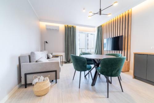 salon ze stołem, krzesłami i kanapą w obiekcie Bella Vista - 3pok, 5 łóżek, centrum, parking, winda, widok na rzekę, Netflix w Iławie