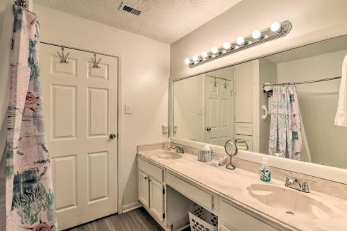 a bathroom with two sinks and a large mirror at Gulf Views and Resort Perks Walkable Galveston Gem in Galveston