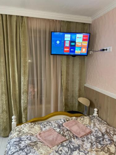 um quarto com uma cama e uma televisão na parede em Renthouse Guest Apartment ALICE em Paide