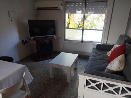 ein Wohnzimmer mit einem Sofa und einem TV in der Unterkunft Castellanos Departamento Temporario in Santa Fe