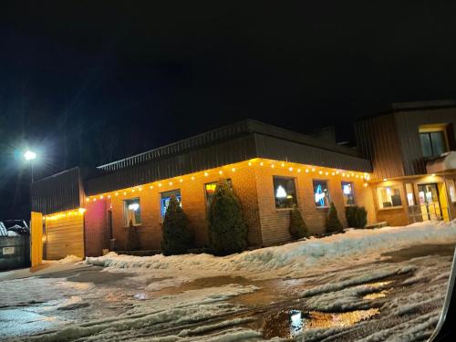 a building with christmas lights in the snow at night at America's Best Value Inn Sandpoint in Sandpoint