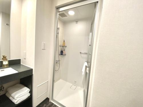 a bathroom with a shower and a sink at hotel MONday Premium Ueno Okachimachi in Tokyo