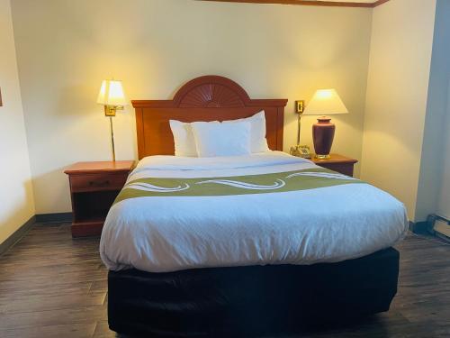 a large bed in a hotel room with two lamps at America's Best Value Inn Sandpoint in Sandpoint