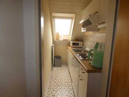 a small kitchen with a sink and a window at To Hus, Whg 3 in Kellenhusen