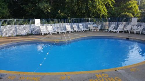 una gran piscina con sillas y una valla en Mentor Home Inn and Suites, en Mentor