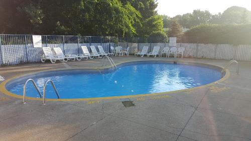 una pequeña piscina con sillas y una valla en Mentor Home Inn and Suites, en Mentor