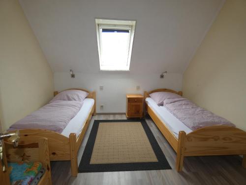 two beds in a small room with a window at To Hus, Whg 4 in Kellenhusen
