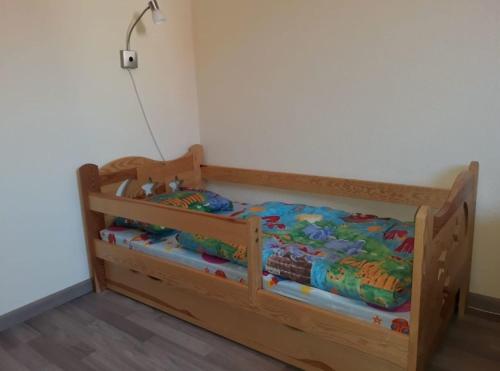 a wooden toddler bed in a room at To Hus, Whg 4 in Kellenhusen