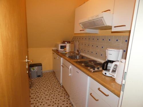 a small kitchen with a sink and a microwave at To Hus, Whg 4 in Kellenhusen